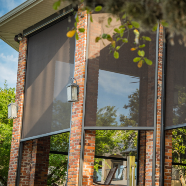 Large motorized screens installed on a brick patio enclosure, providing shade, insect protection, and comfortable outdoor living for a Florida home.