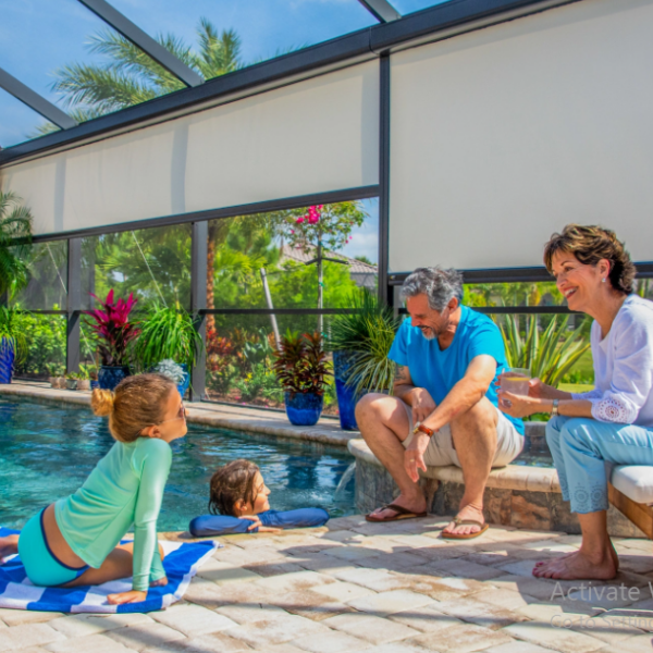 Motorized patio screens surrounding a Florida pool enclosure while a family enjoys shade, privacy, and comfortable outdoor living.