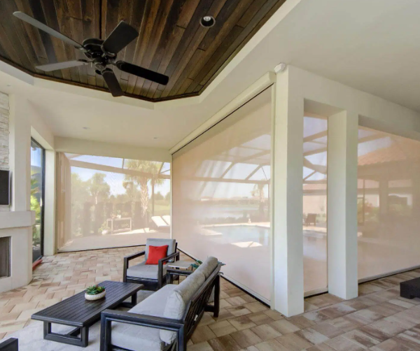 Motorized patio screens enclosing a luxury outdoor living space, providing shade, privacy, and protection while preserving views of the pool and landscape.
