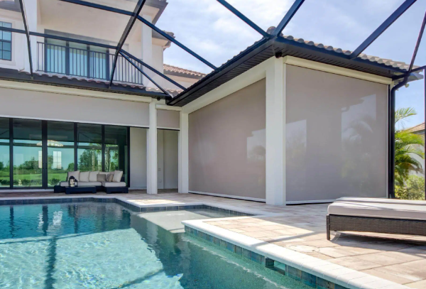 Large motorized screens installed around a luxury Florida pool enclosure, providing shade, privacy, and protection while preserving outdoor views.