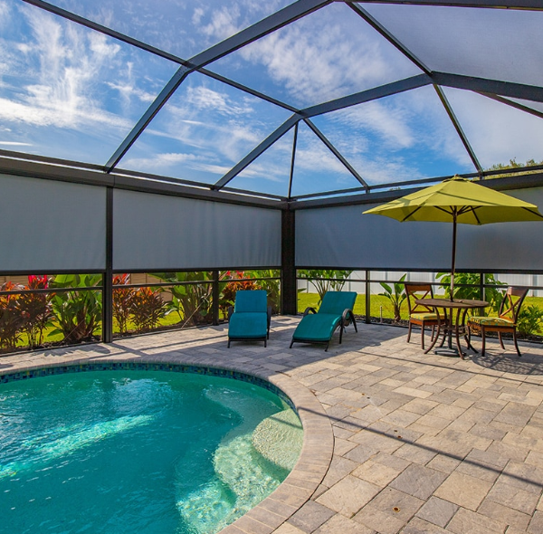 Motorized screens installed inside a Florida pool enclosure, providing shade, privacy, and sun protection while maintaining an open outdoor living space.